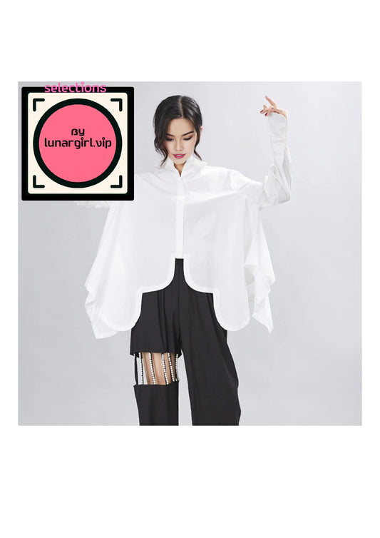 
This white avant-garde designed, oversized shirt features a classic collar, which adds a touch of formality and structure to the otherwise relaxed silhouette. The neckline is traditional, with a button-up front that allows for adjustable styling.

The long sleeves are designed with buttoned cuffs, which can be rolled up for a more casual look or left down for a polished appearance. The sleeves are slightly puffed at the shoulders, adding a subtle volume that enhances the blouse’s oversized nature.

The bod